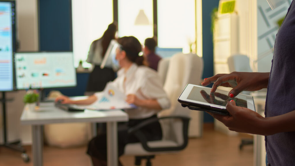 Close up of african employee using tablet standing in office